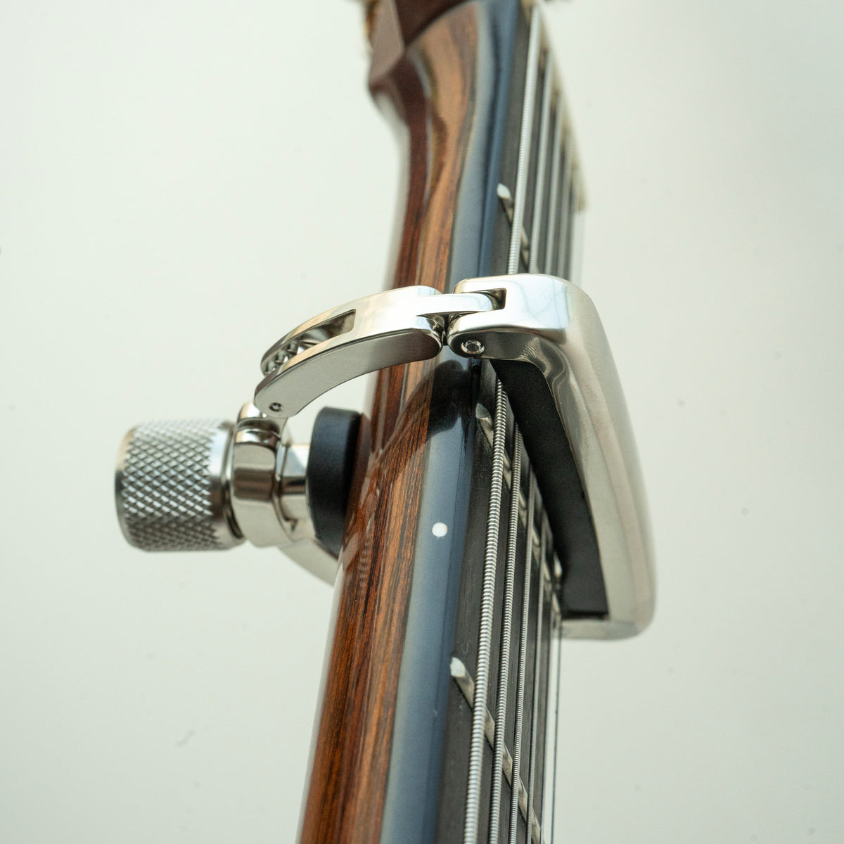 Black Mountain Capo pad settling onto six guitar strings