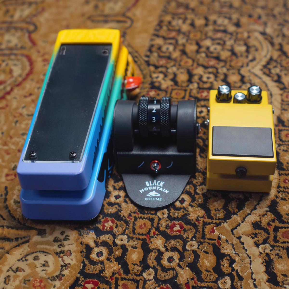 Black Mountain Volume Pedal between two traditional guitar pedals for size comparison