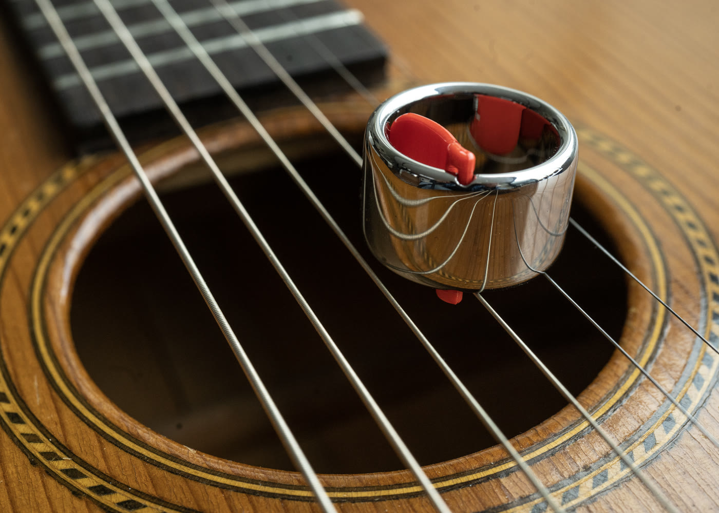 Current Black Mountain Tungsten Slide Ring resting on an acoustic guitar